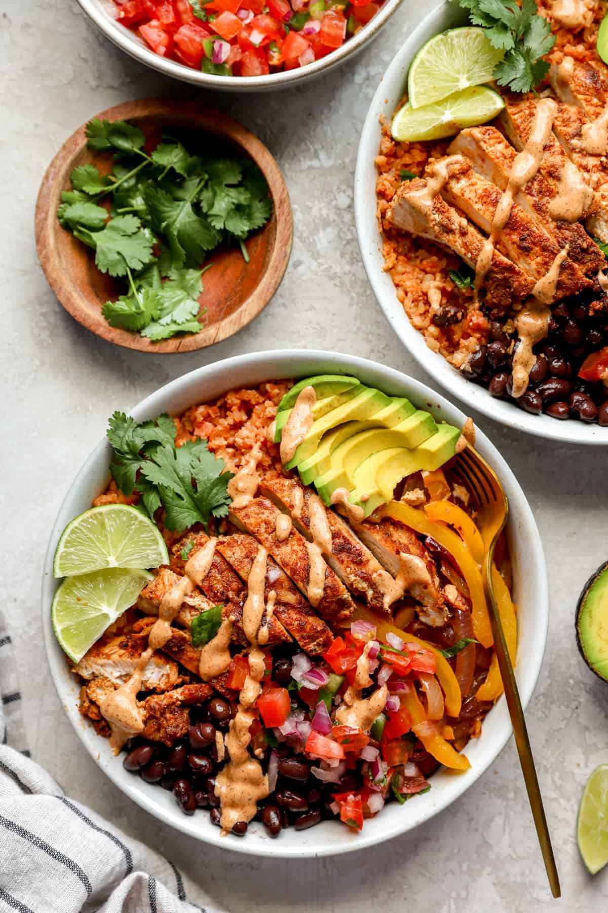 A copycat chipotle chicken bowl with sauce drizzled on top!