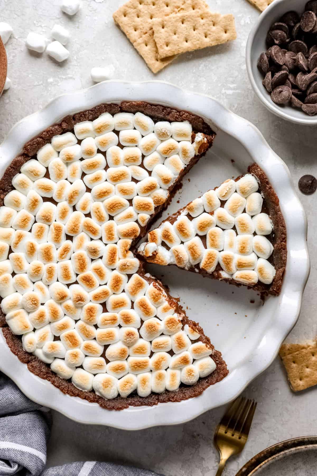 S'mores pie with two pieces missing and one slice cut.