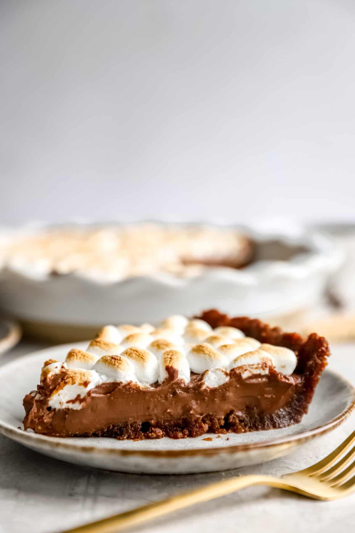 Side view of a slice of s'mores pie on a plate. 