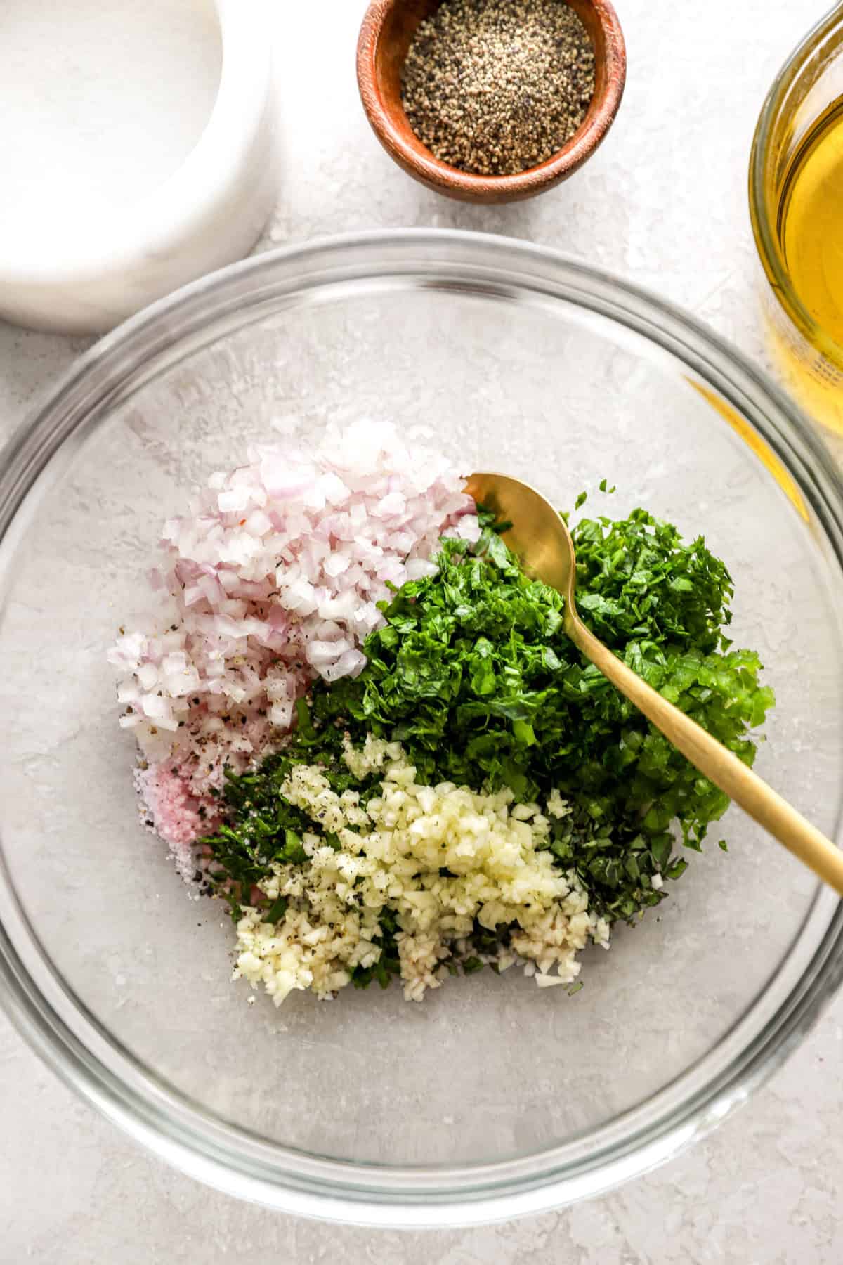 Chimichurri ingredients in a glass bowl.