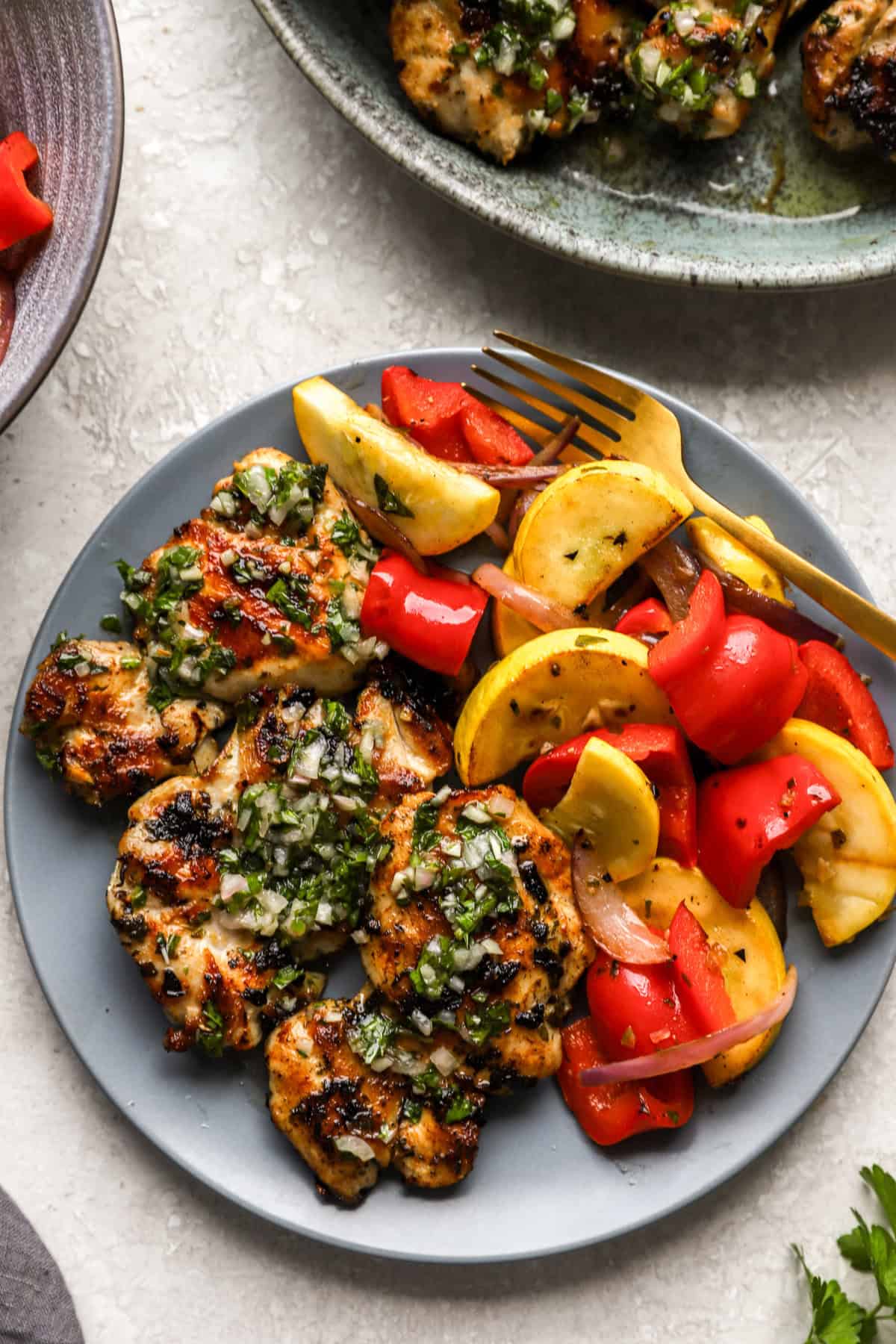 A plate of chimichurri chicken and veggies.