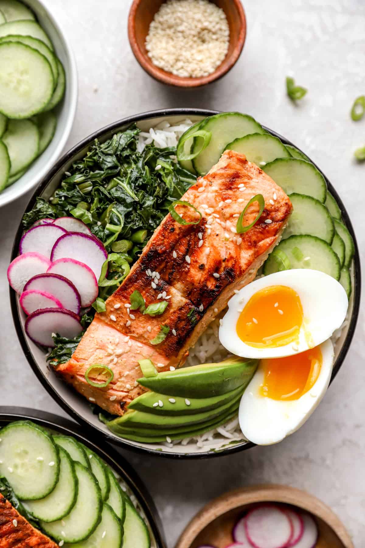 A grilled salmon bowl with garlicky kale and eggs. 