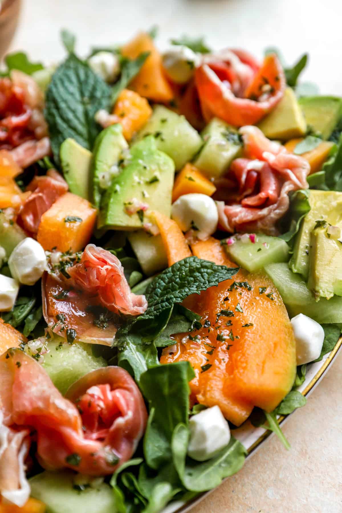 A platter of melon and prosciutto salad. 