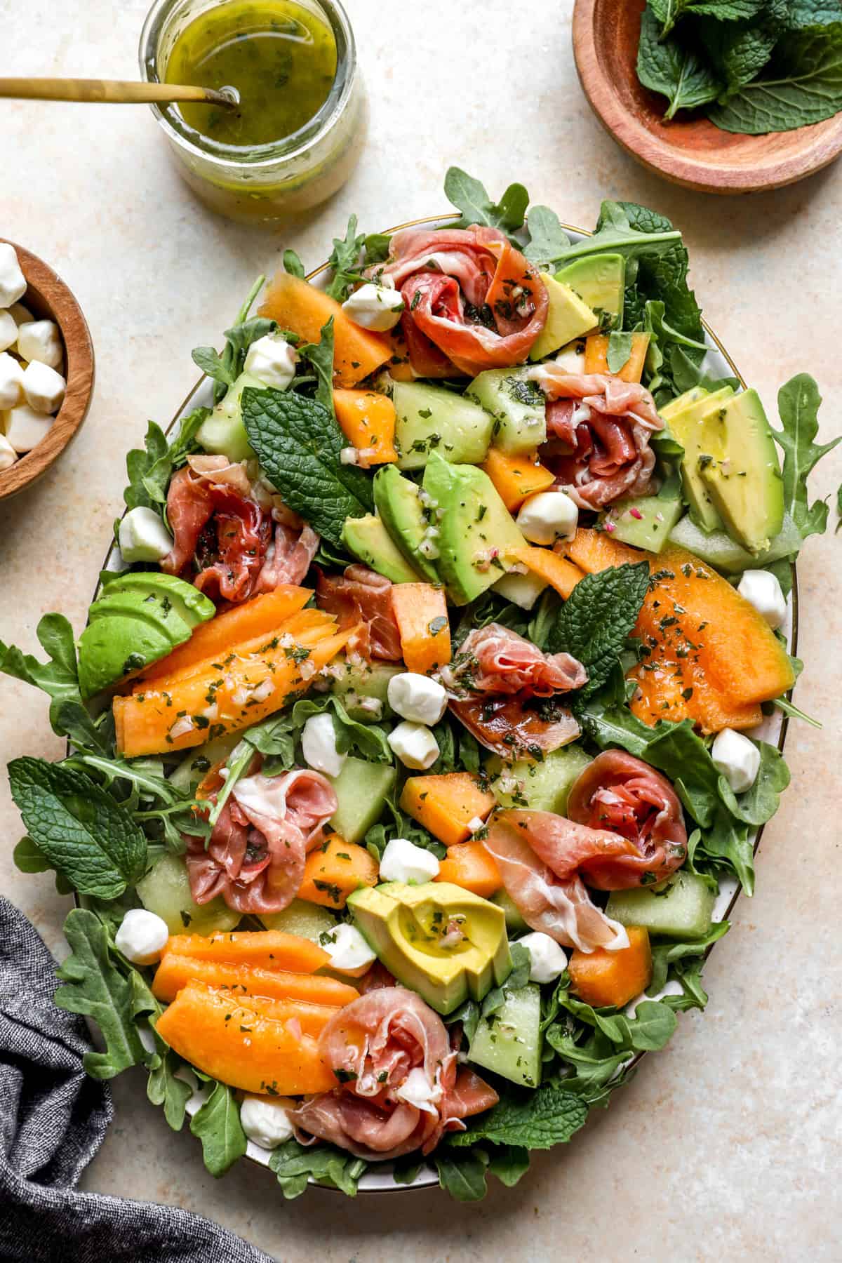 A platter of melon salad with prosciutto. 