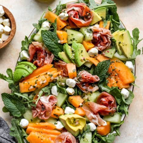 A platter of melon salad with prosciutto.