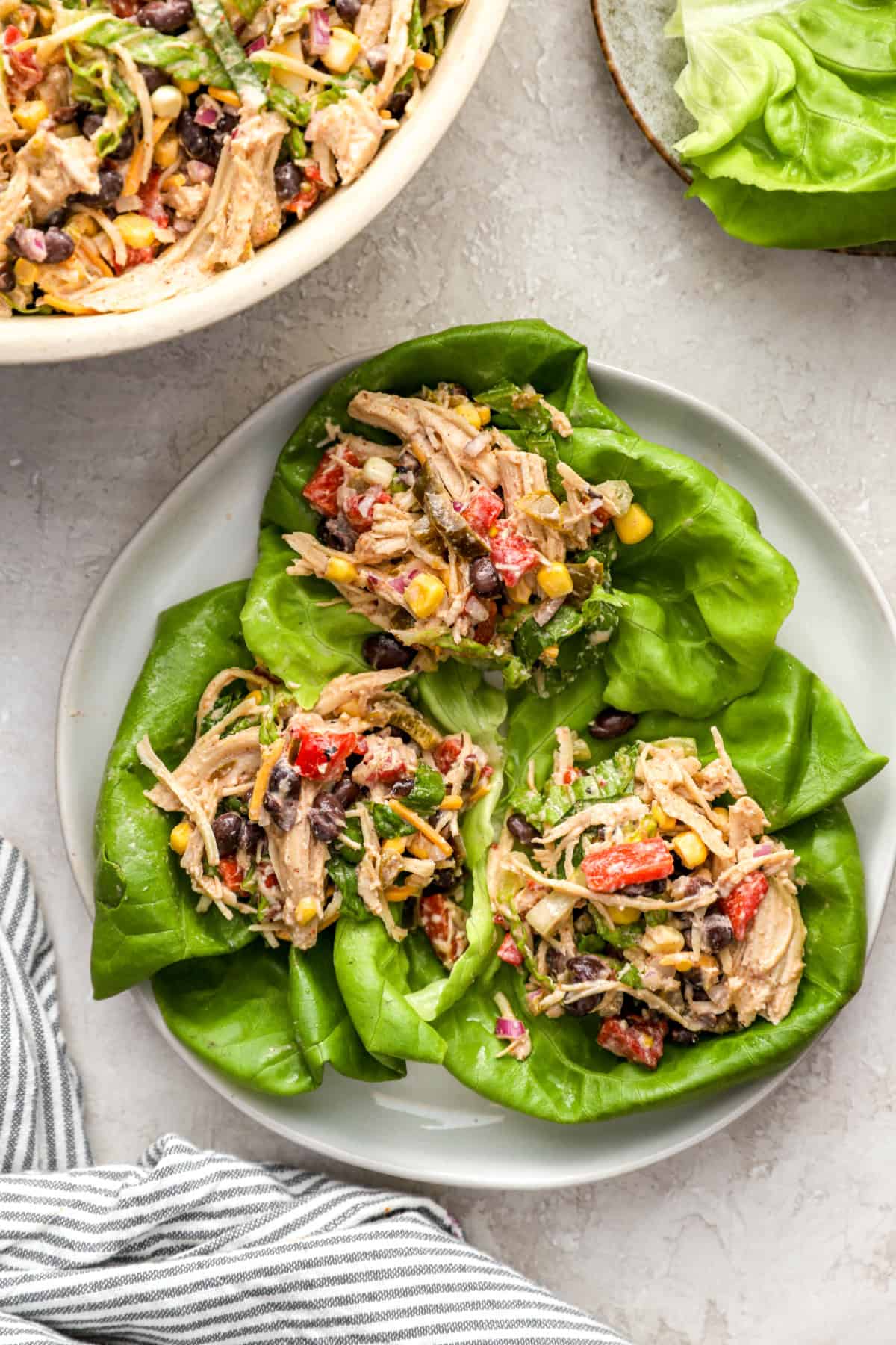 Chicken taco salad in lettuce wraps on a plate. 