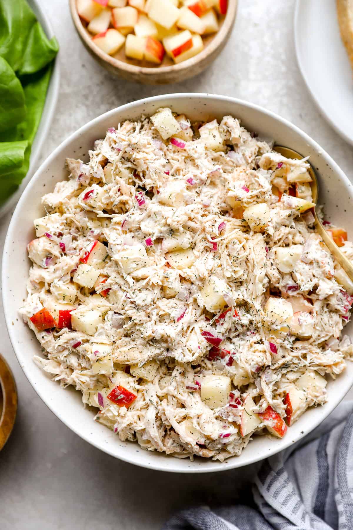 Ensalada de pollo de eneldo de manzana en un tazón de servicio blanco.