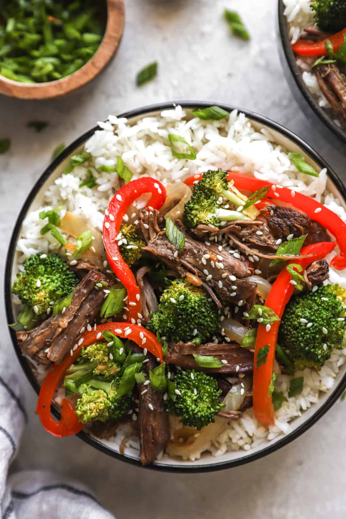 A bowl of slow cooker Asian beef and peppers over rice. 