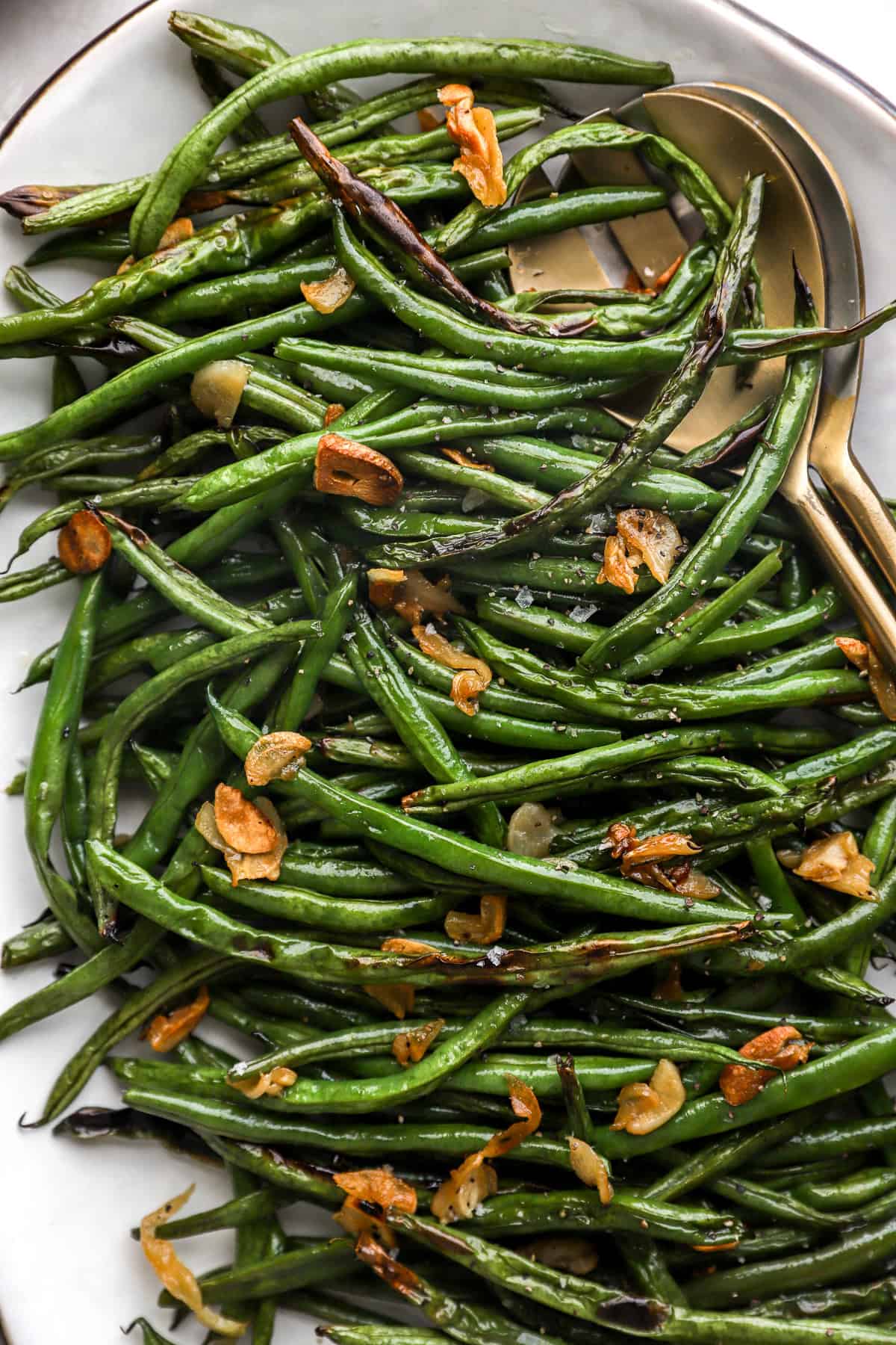 A platter of garlicky blistered green beans topped with almonds. 