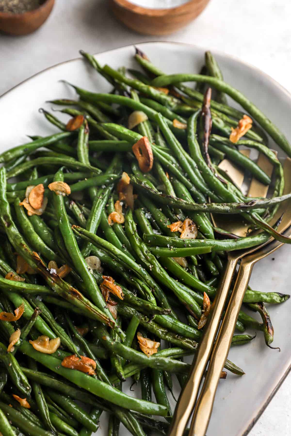 Close up image of blistered green beans on a platter. 