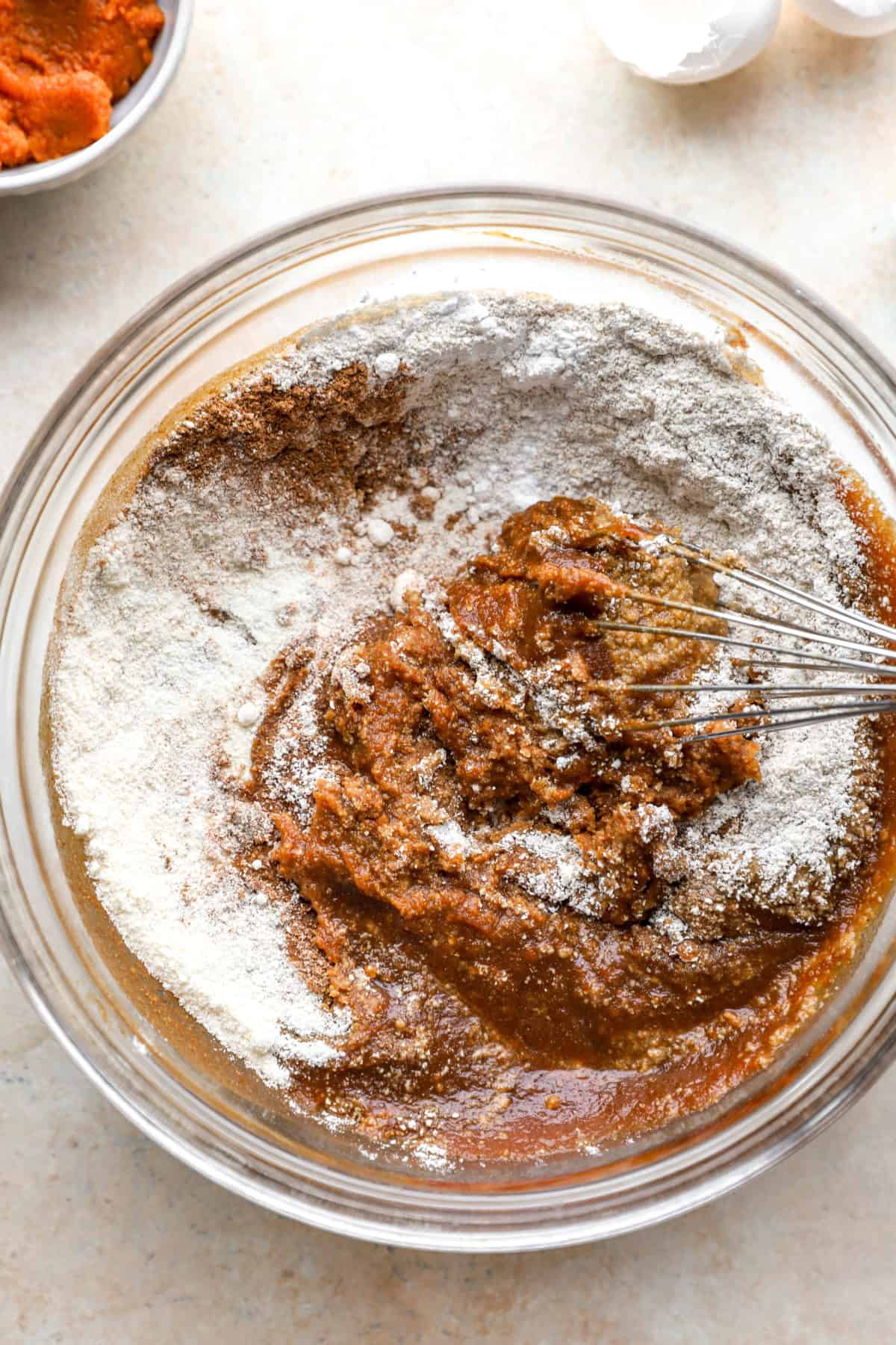 Pumpkin cake batter ingredients being whisked in a bowl.