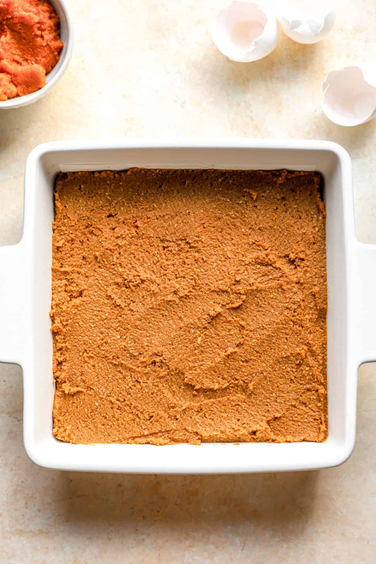 Unbaked gluten free pumpkin cake in a square baking dish.