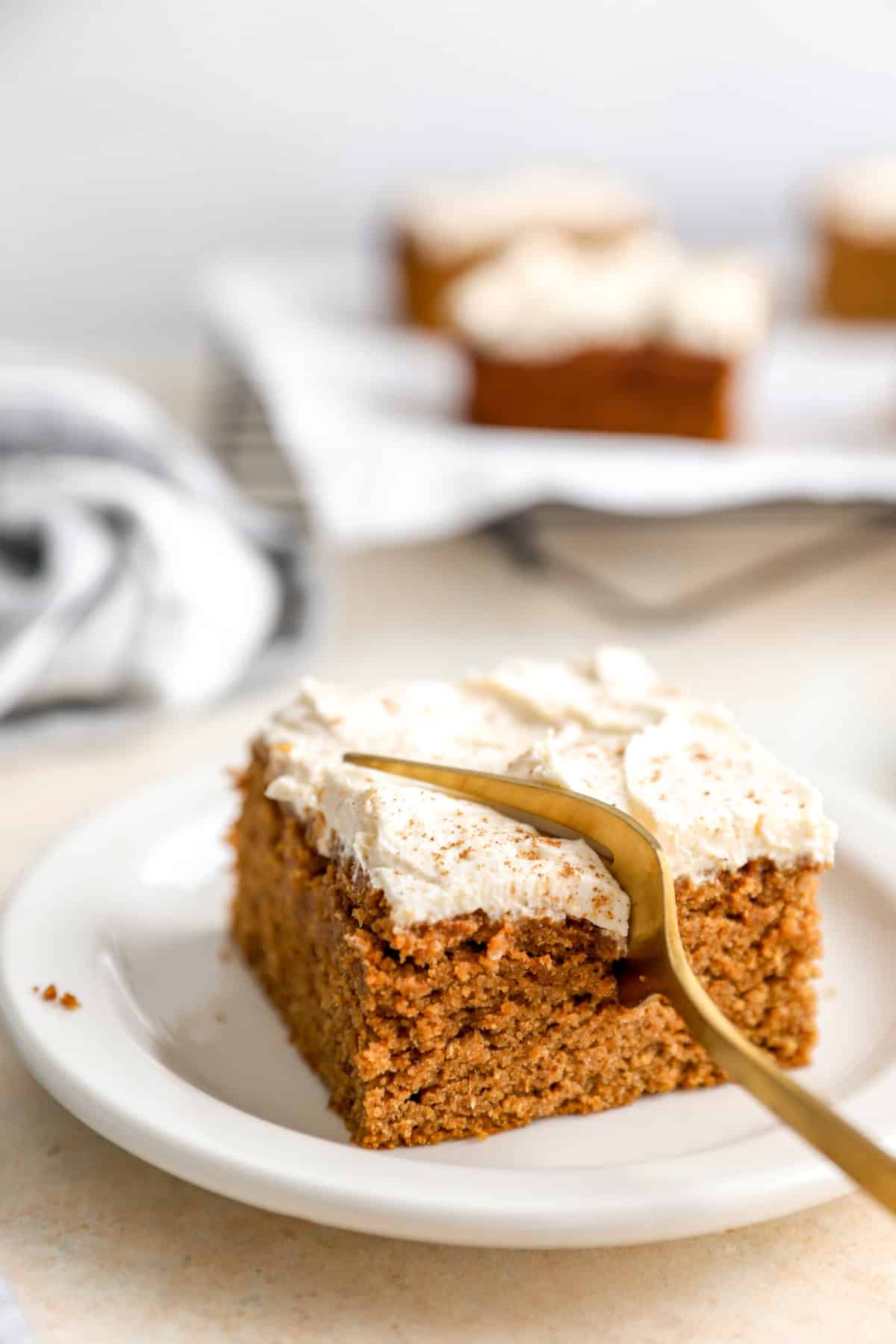 A slice of gluten-free pumpkin cake with a fork cutting a bite. 