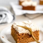 A slice of gluten-free pumpkin cake with a fork cutting a bite.