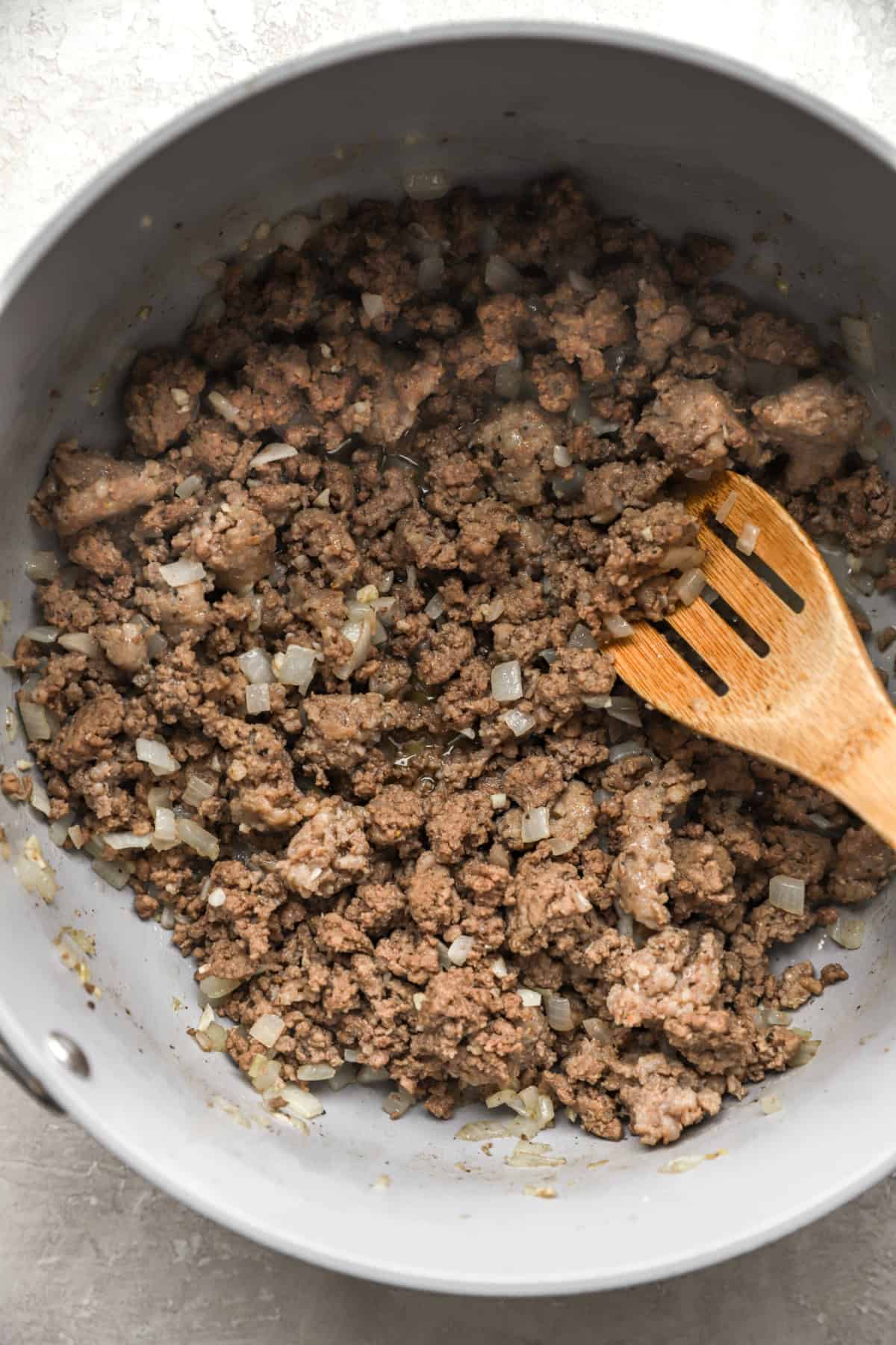 Ground beef cooking in a Dutch oven.