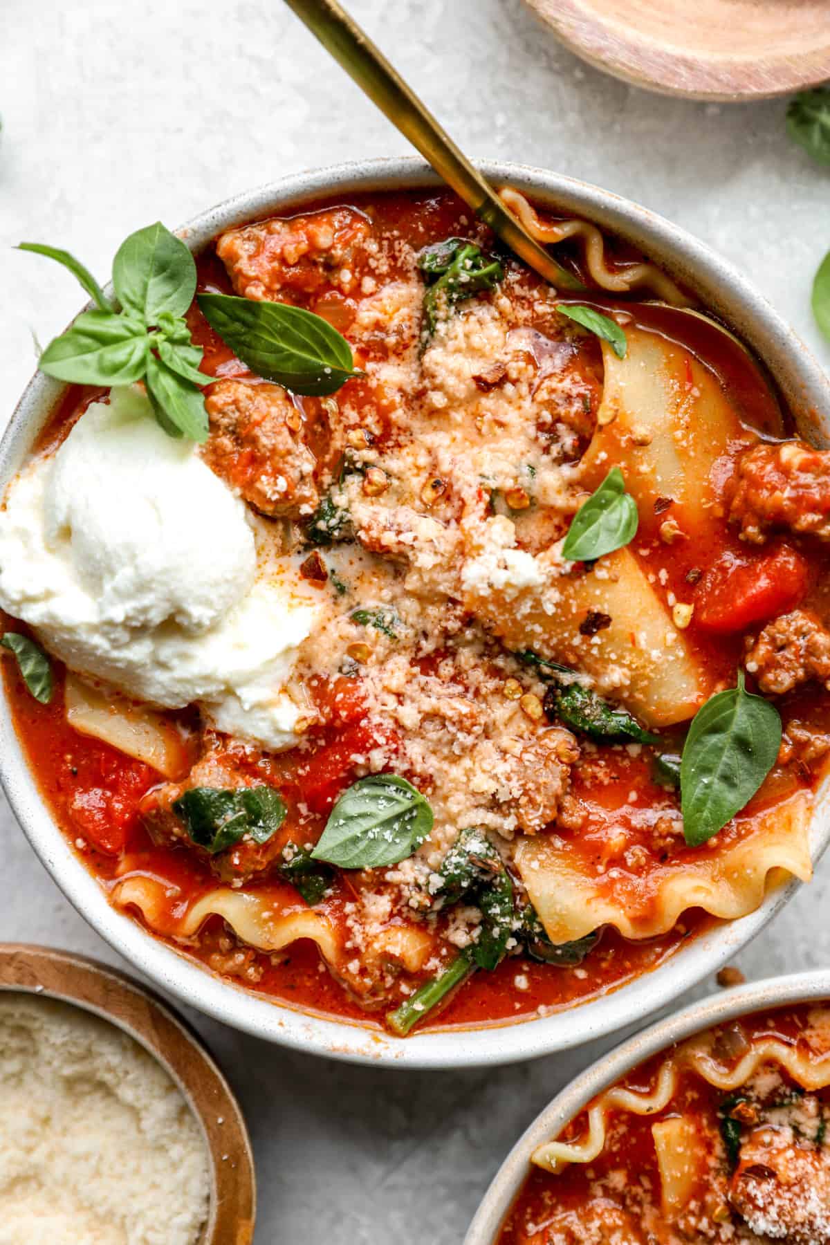 A bowl of gluten-free lasagna soup with a spoon sticking out. 