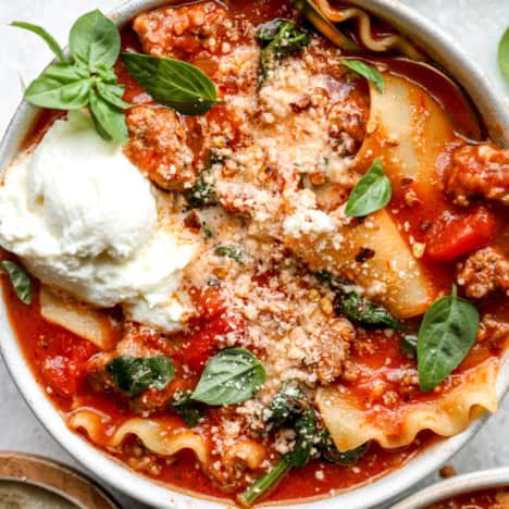 A bowl of gluten-free lasagna soup with a spoon sticking out.