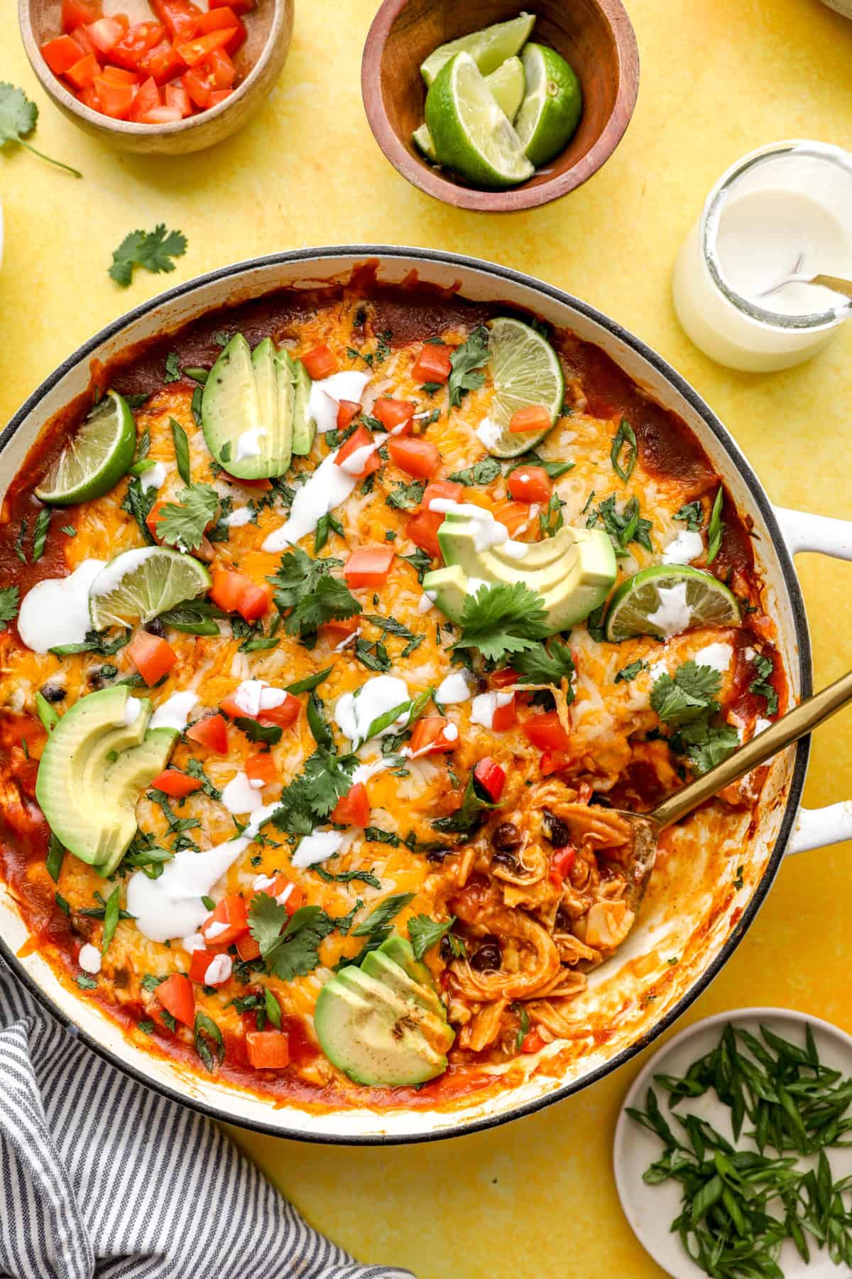 Overhead image of chicken skillet enchiladas with a spoon sticking out. 