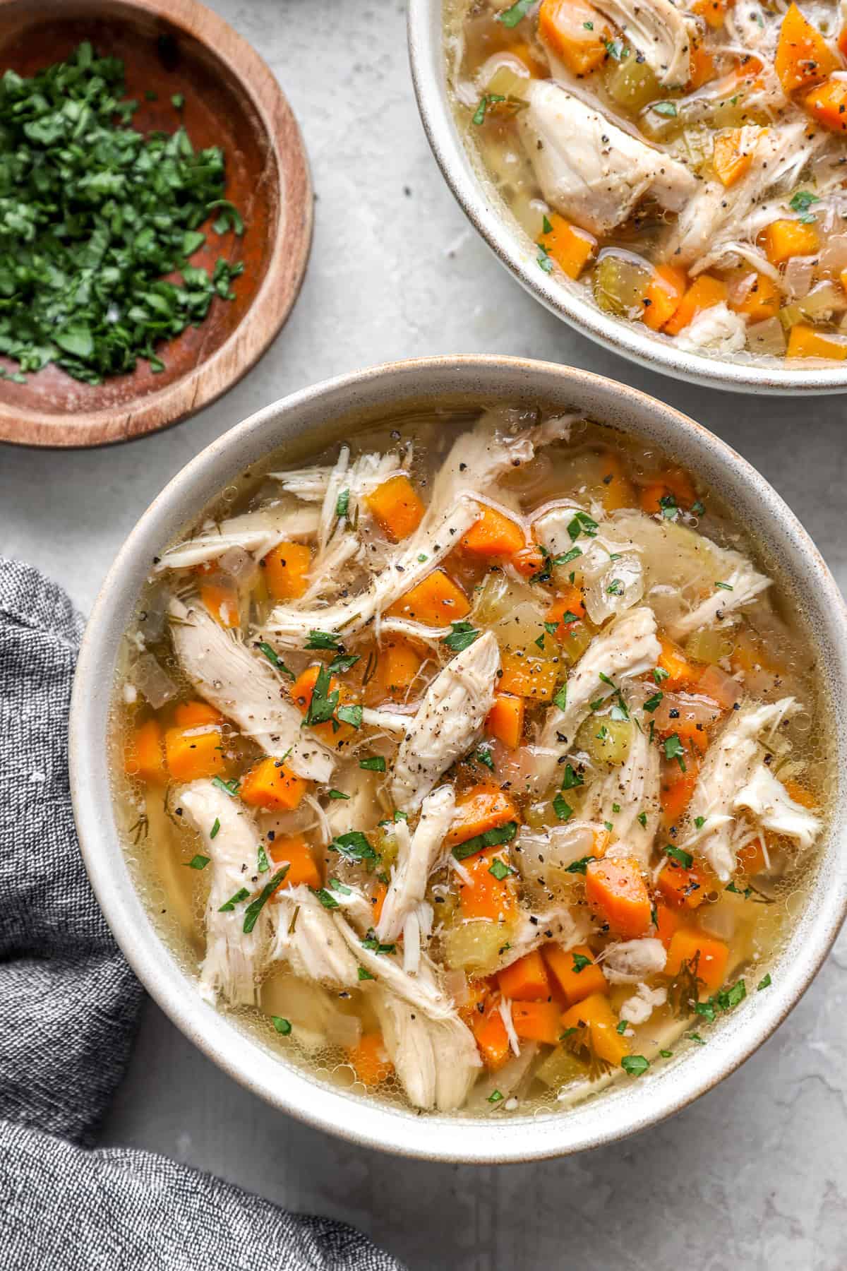 A bowl of slow cooker chicken soup with vegetables. 