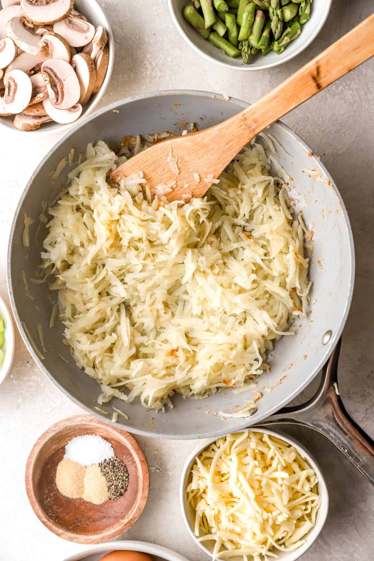 Hash browns cooking in a skillet.