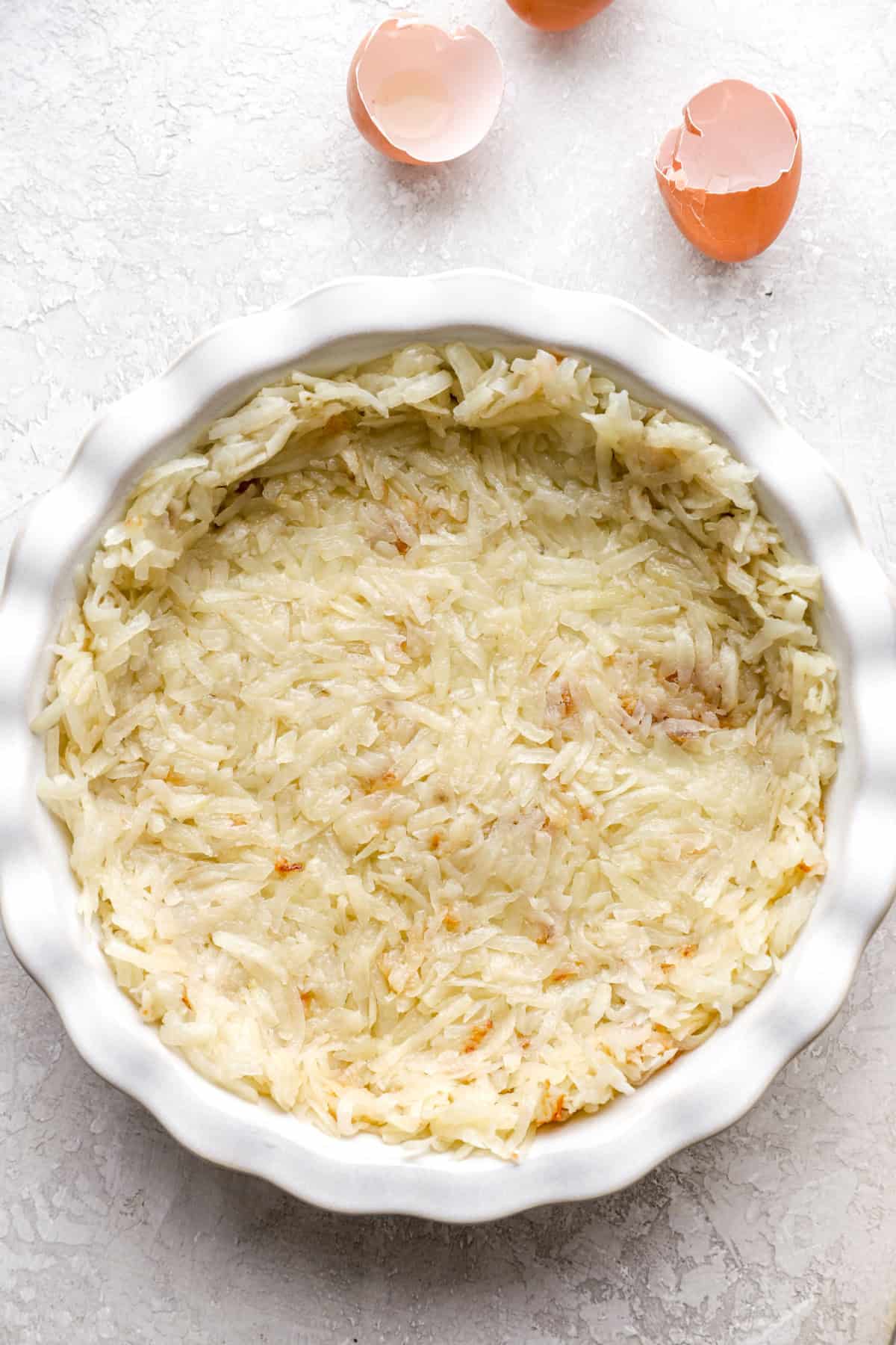 Hash browns layered in a pie dish to create a crust.