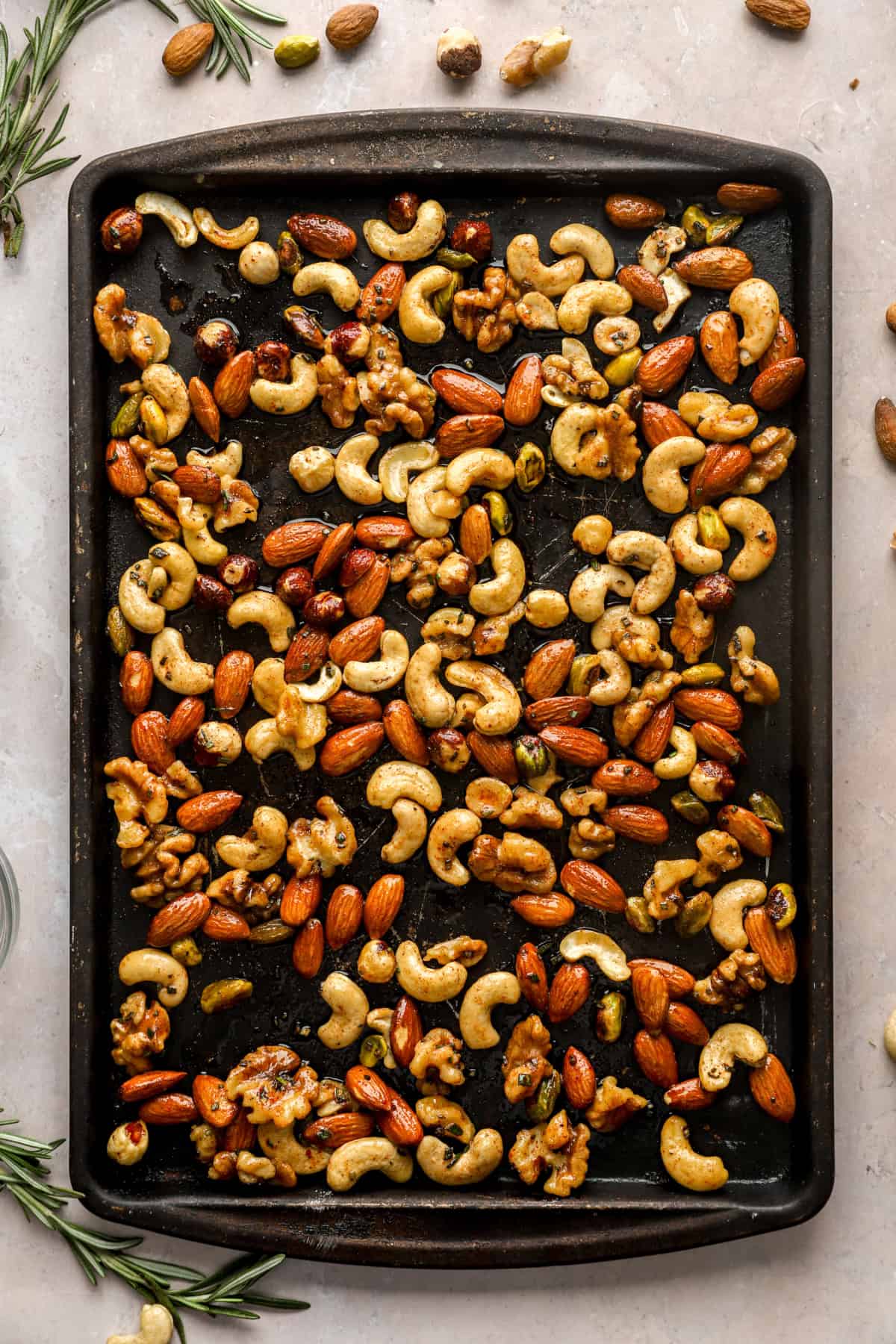 Raw spiced nuts on a baking sheet. 