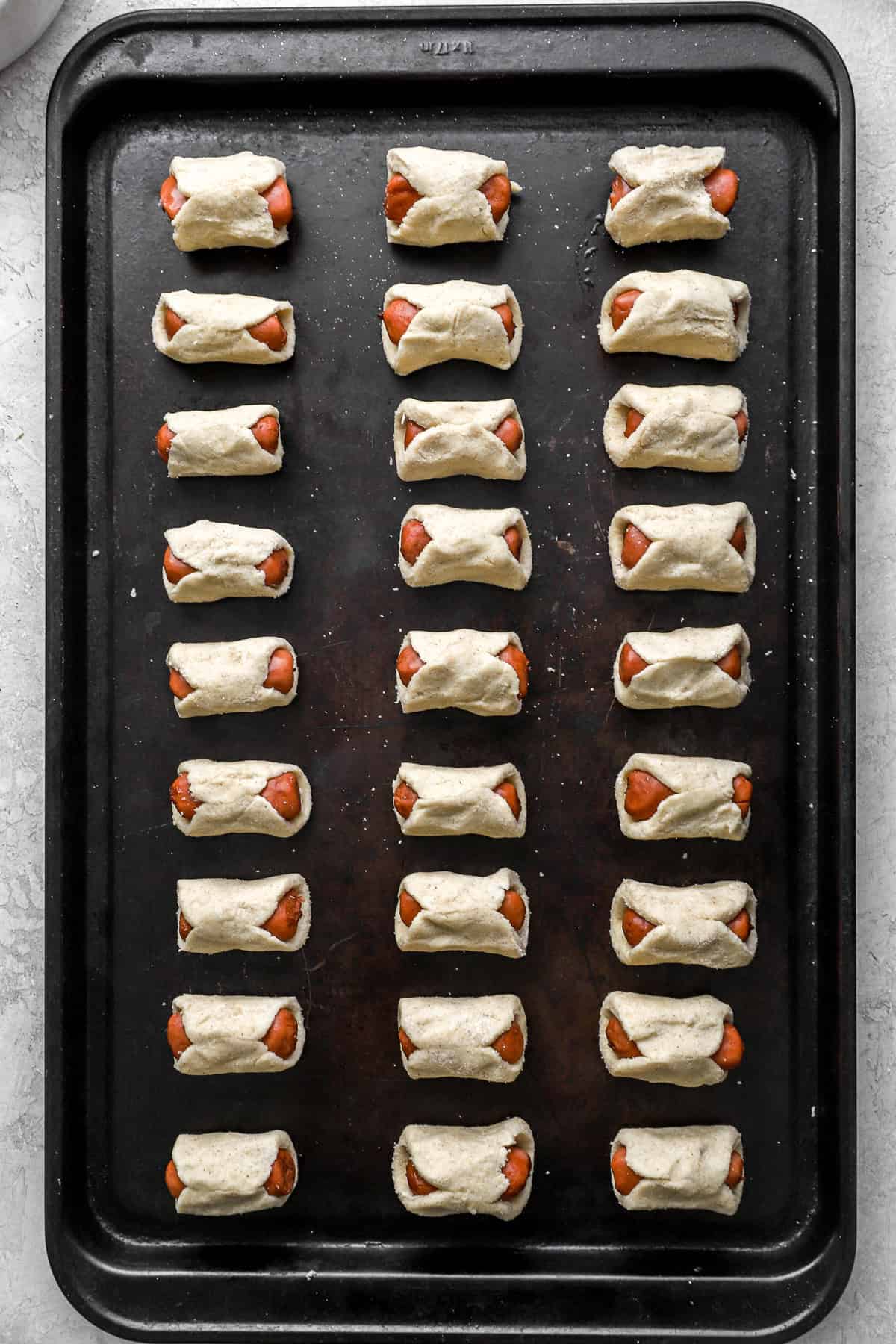 Gluten free pigs in a blanket on a baking sheet. 