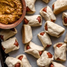 Gluten free pigs in a blanket on a baking sheet.