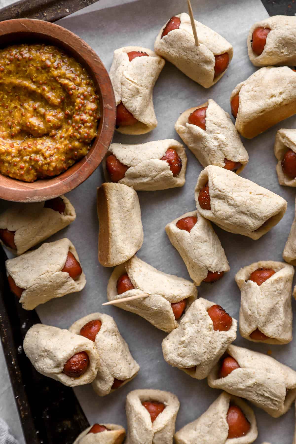 Gluten free pigs in a blanket on a baking sheet.