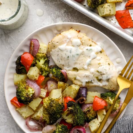 A plate of baked Ranch chicken and vegetables.