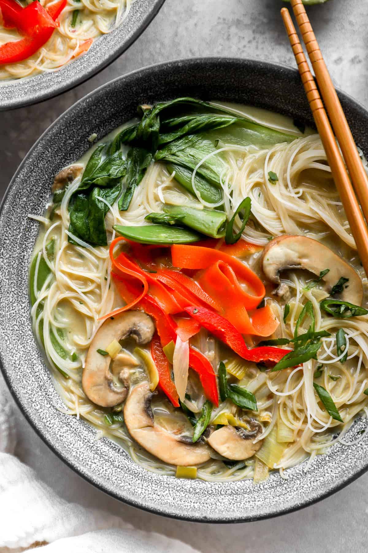 A bowl of coconut curry ramen with chopsticks on top. 