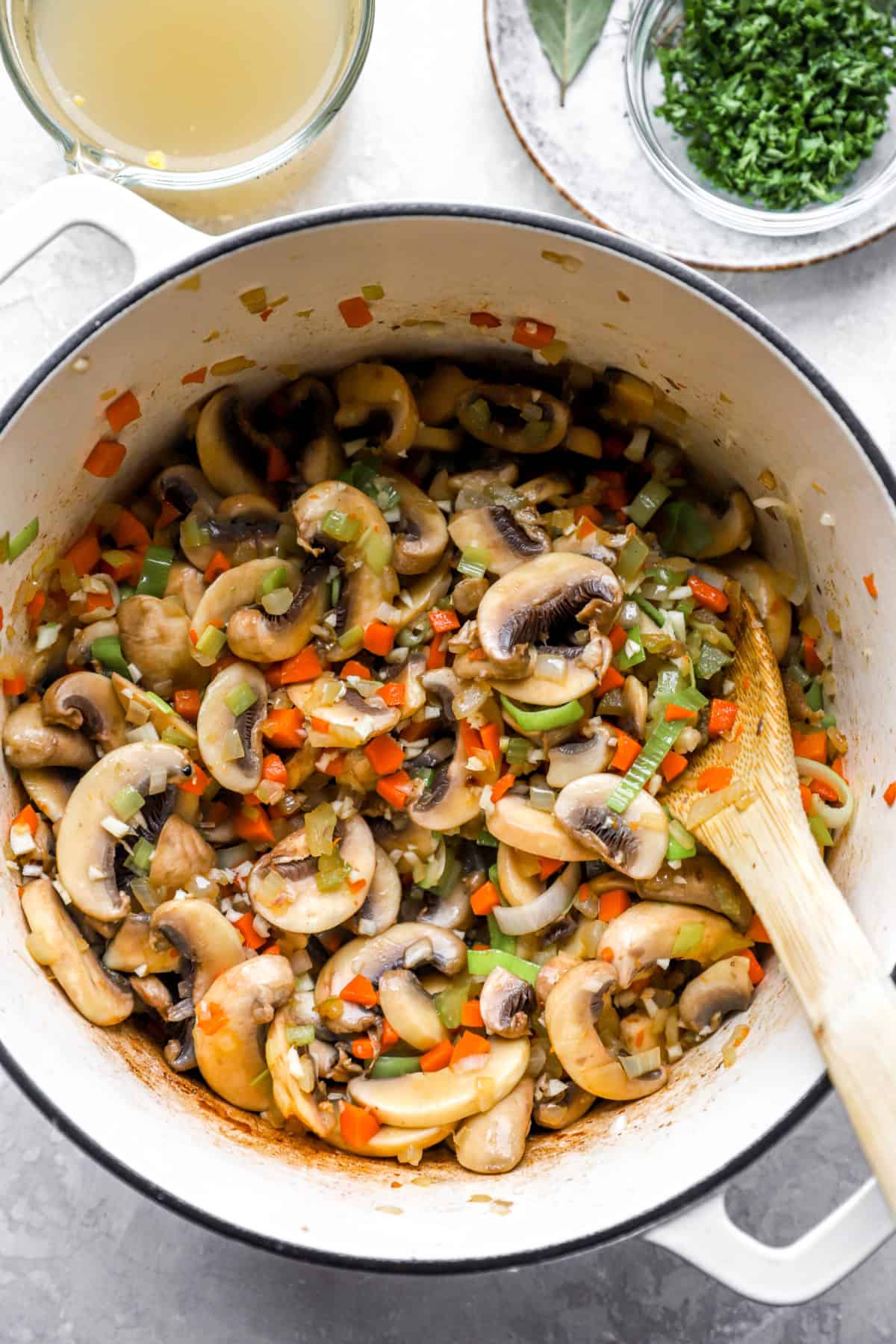 Mushrooms, carrots, celery, and onions cooking in a Dutch oven.