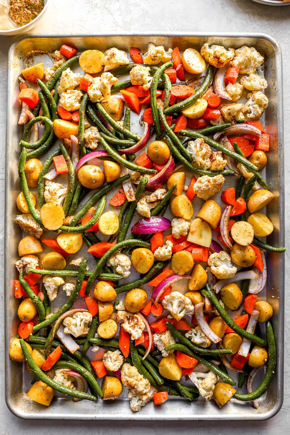 Seasoned mixed vegetables on a baking sheet. 