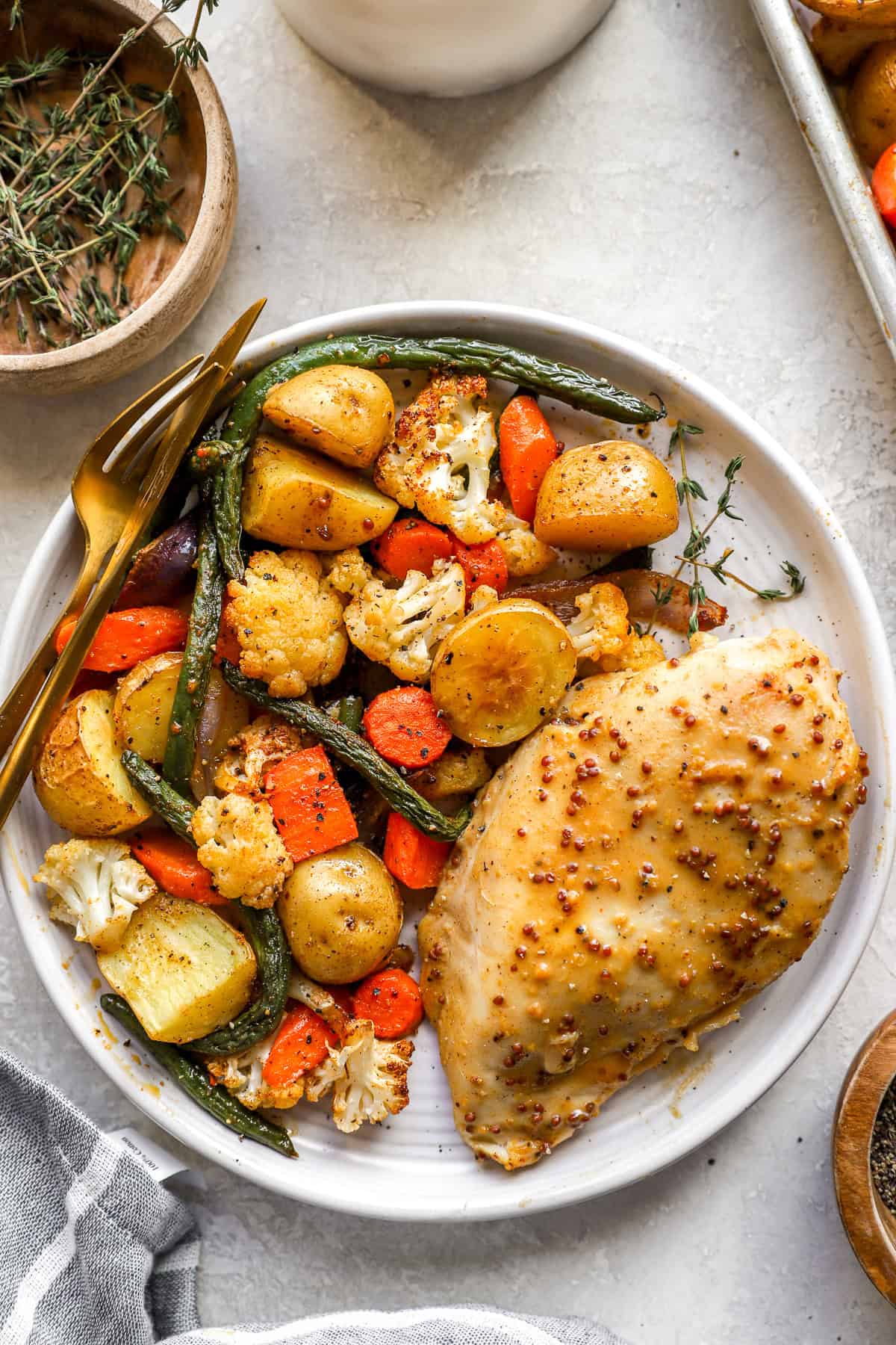 Baked honey mustard chicken and vegetables on a plate.