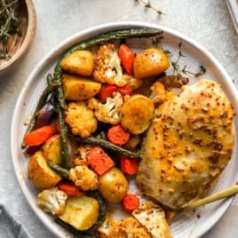 Honey mustard chicken and veggies on a plate.