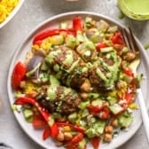 A plate of kofta meatballs with veggies, chickpeas, turmeric rice, and green tahini.