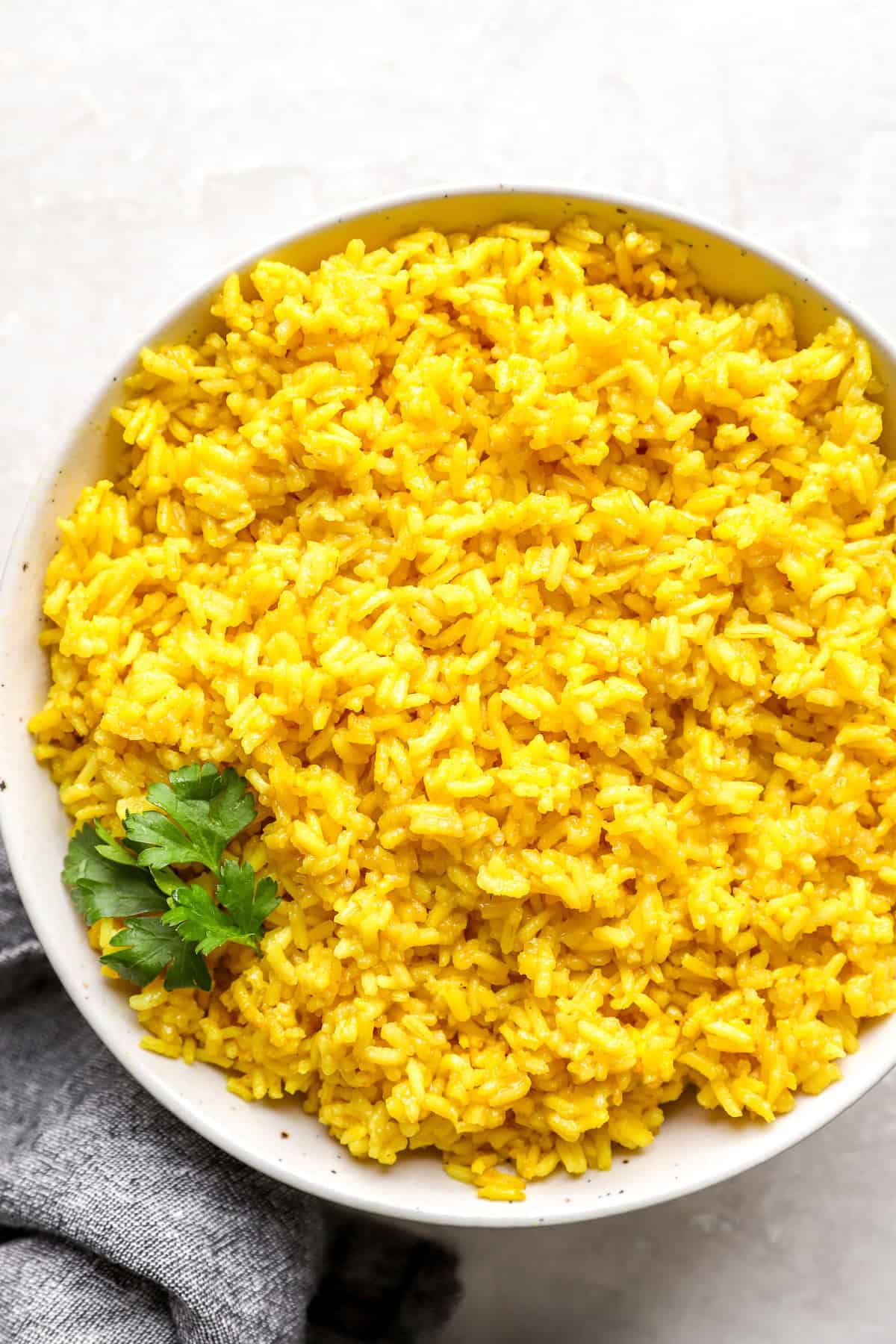 A bowl of turmeric rice with cilantro on top.