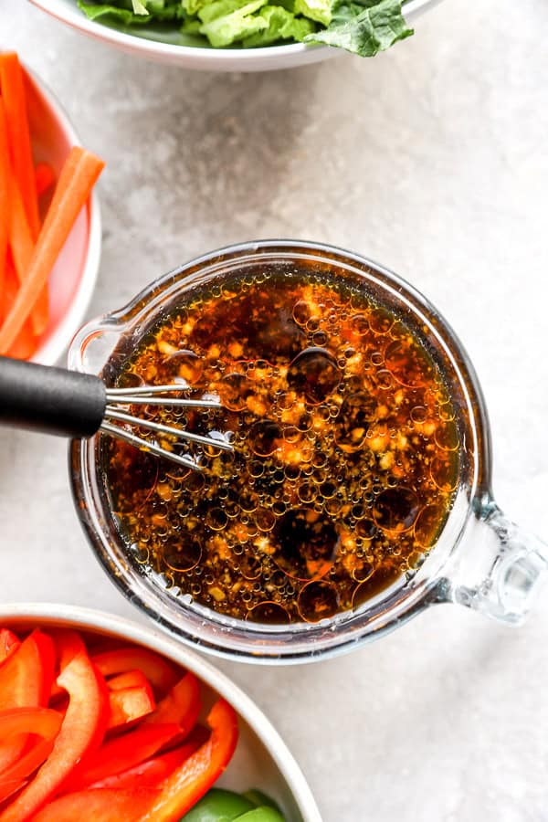 Mongolian beef sauce being whisked in a liquid measuring cup. 