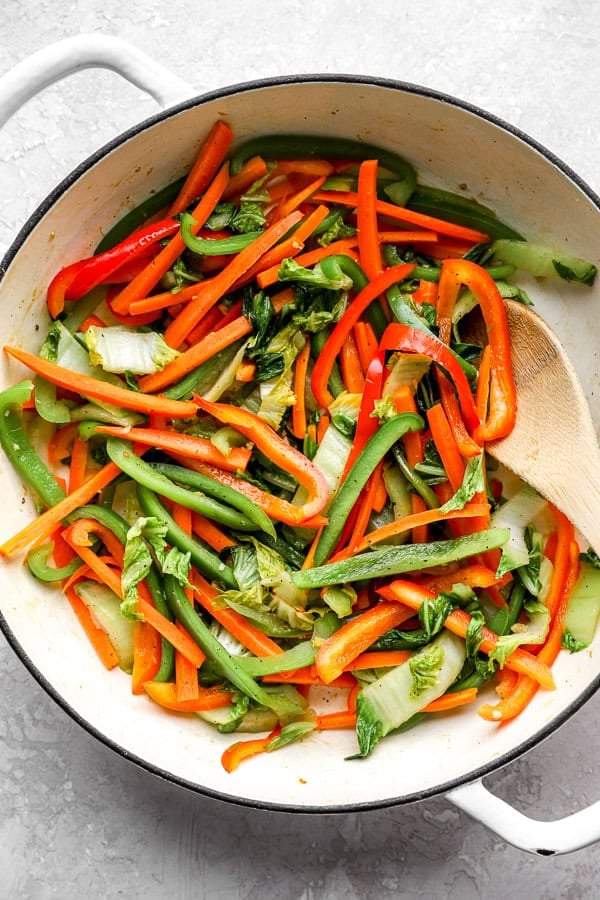 Bell peppers sautéing in a skillet. 