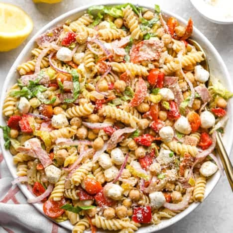 A bowl of Italian grinder pasta salad with a spoon sticking out.