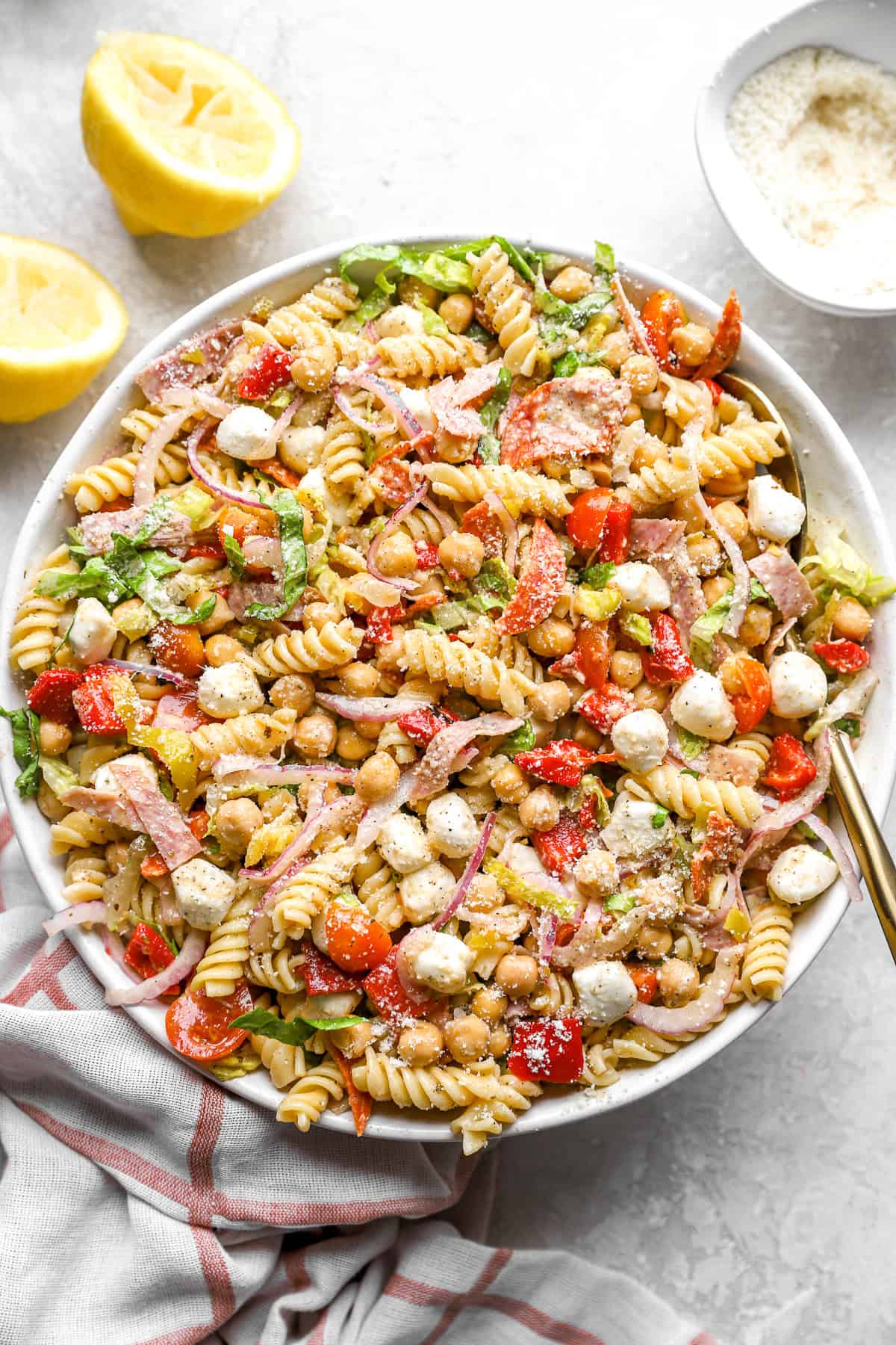 A bowl of Italian grinder pasta salad with a spoon sticking out. 