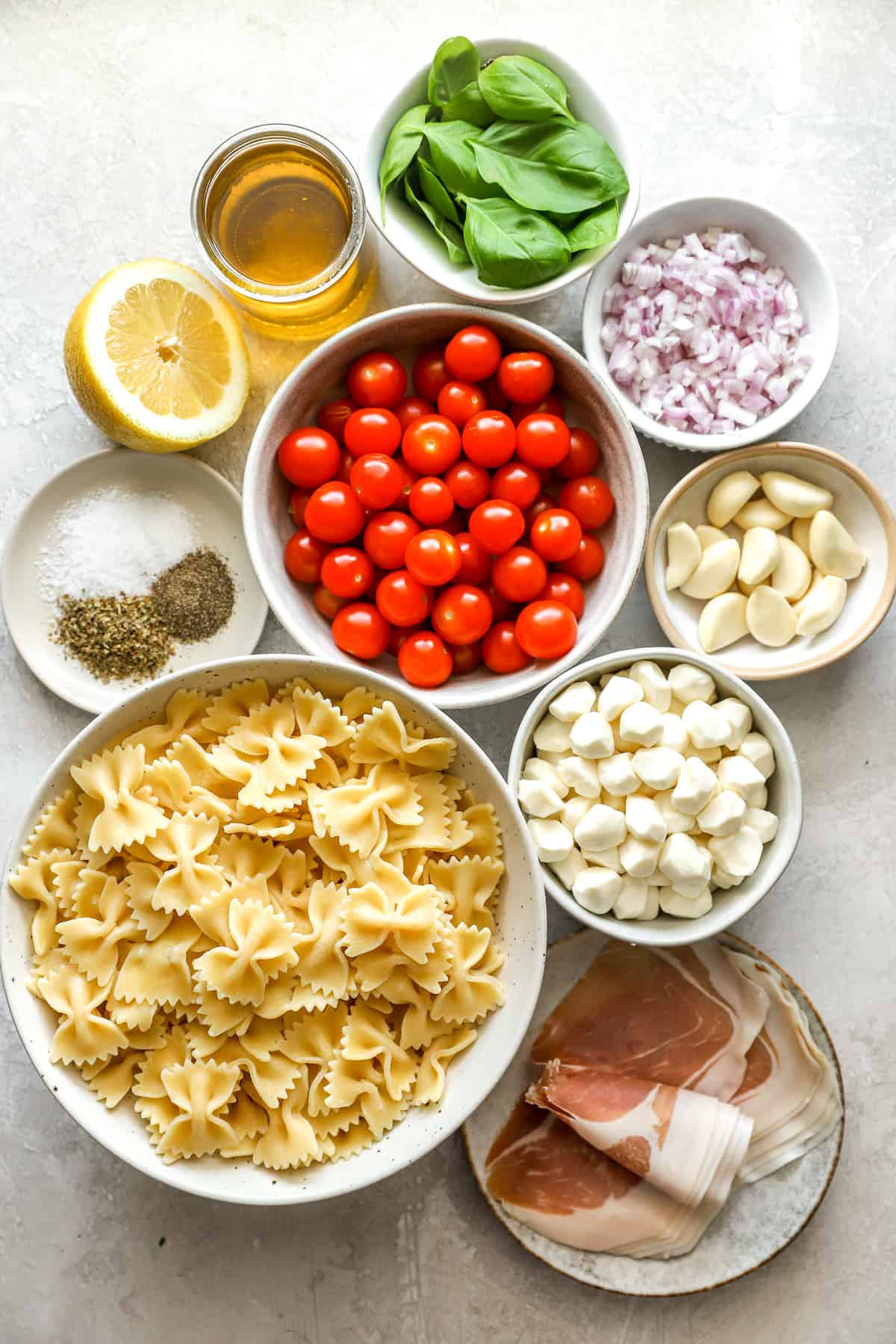 Ingredients to make a caprese pasta salad with garlic confit. 