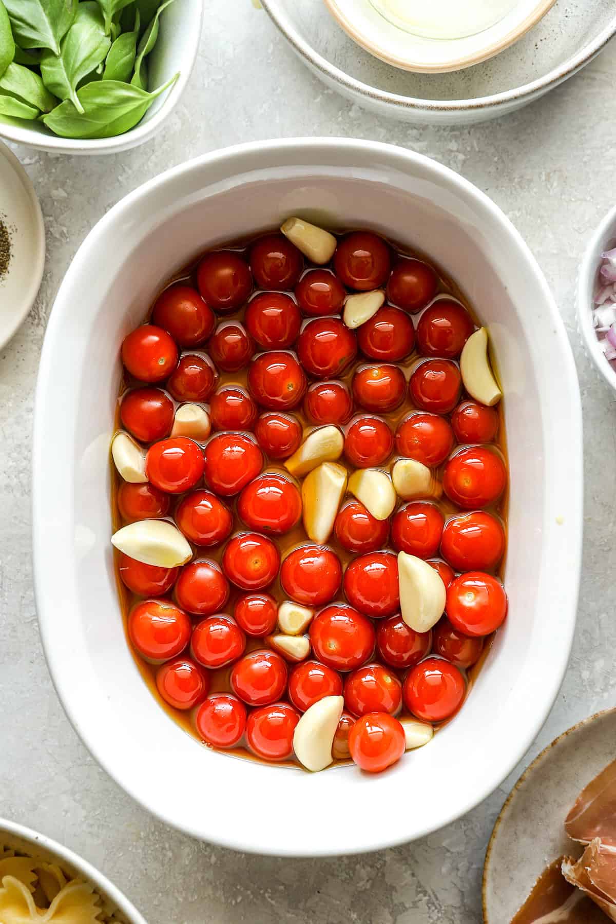 A baking dish with tomato and garlic. 