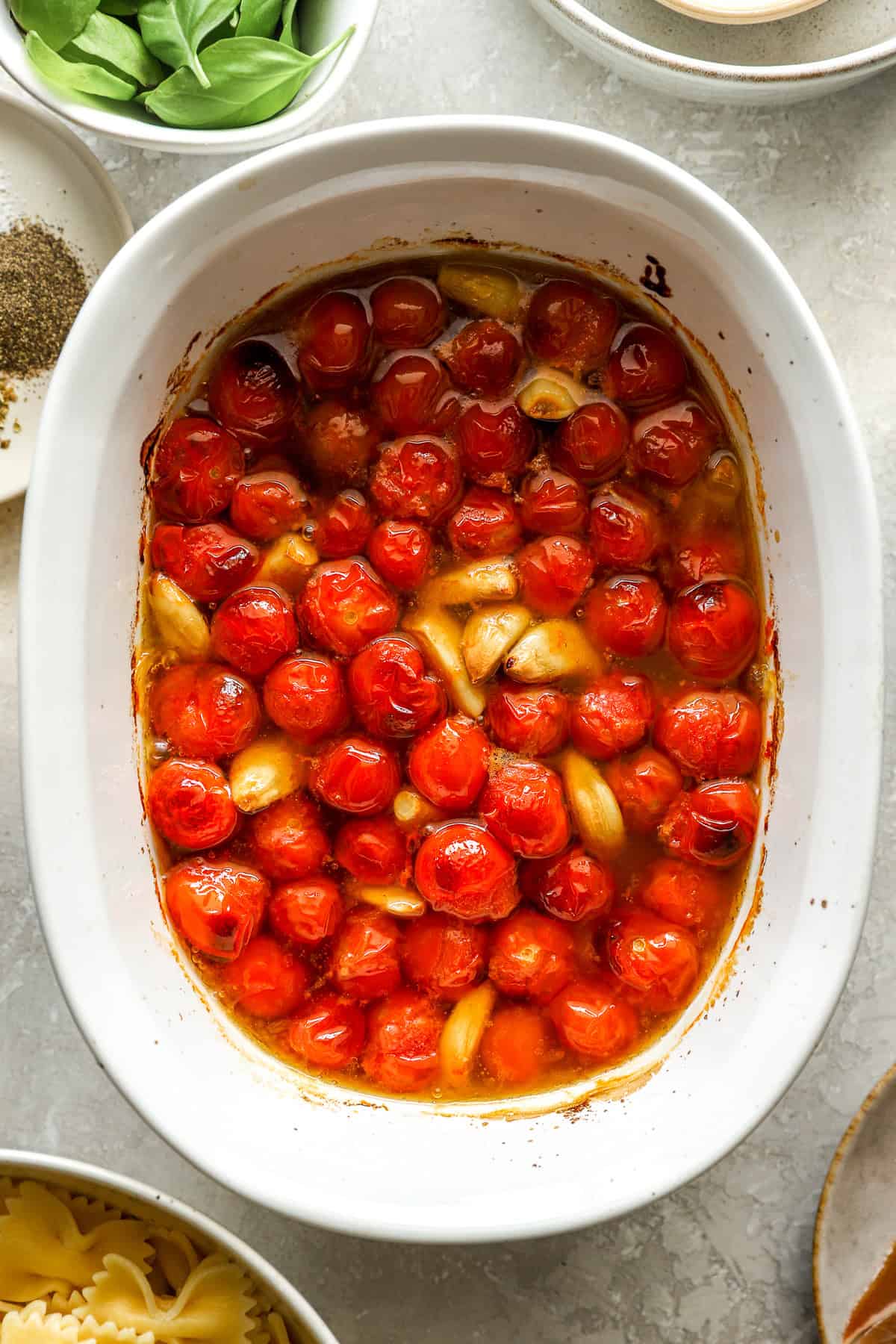 Roasted garlic and tomatoes in a baking dish. 