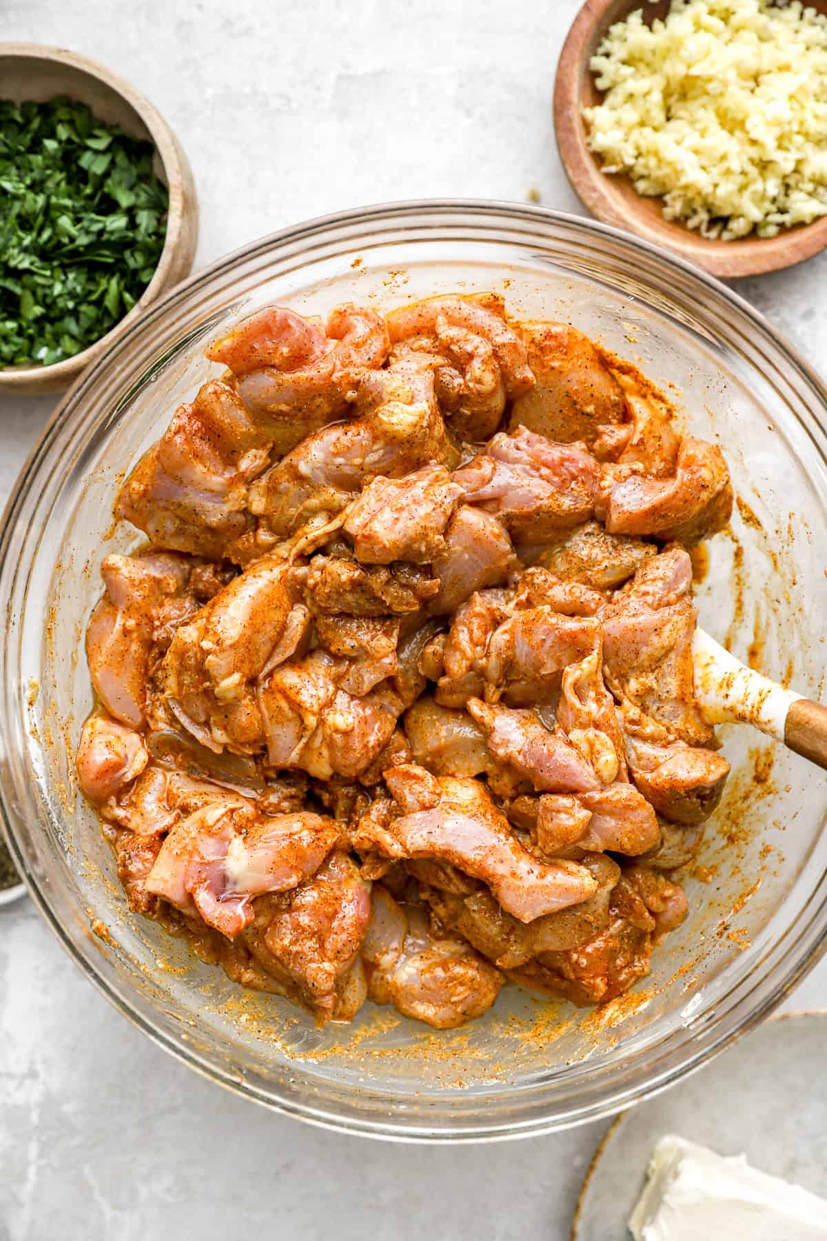 Raw chicken pieces marinating in a bowl. 