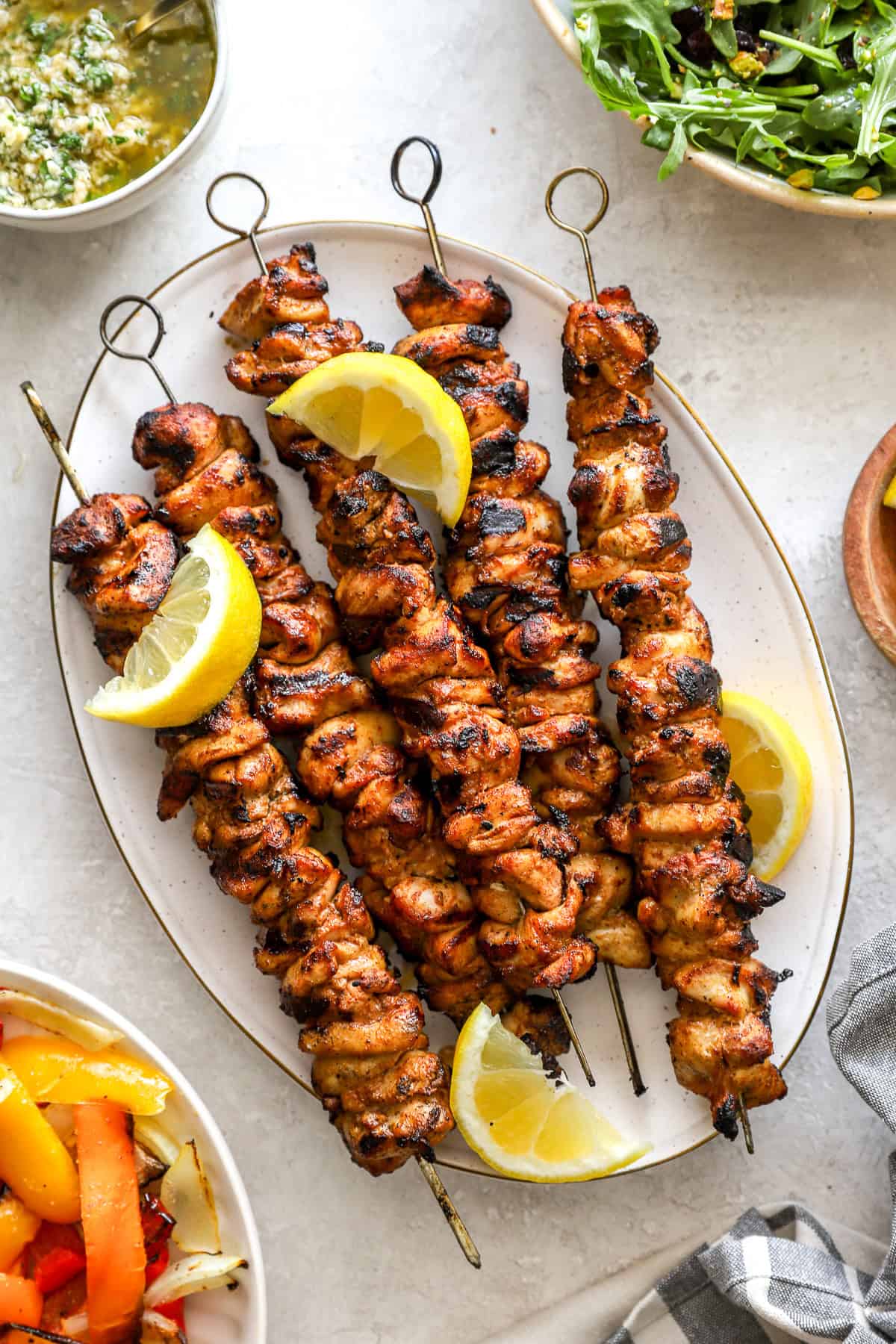 Grilled lemon pepper Parmesan chicken skewers on a platter. 