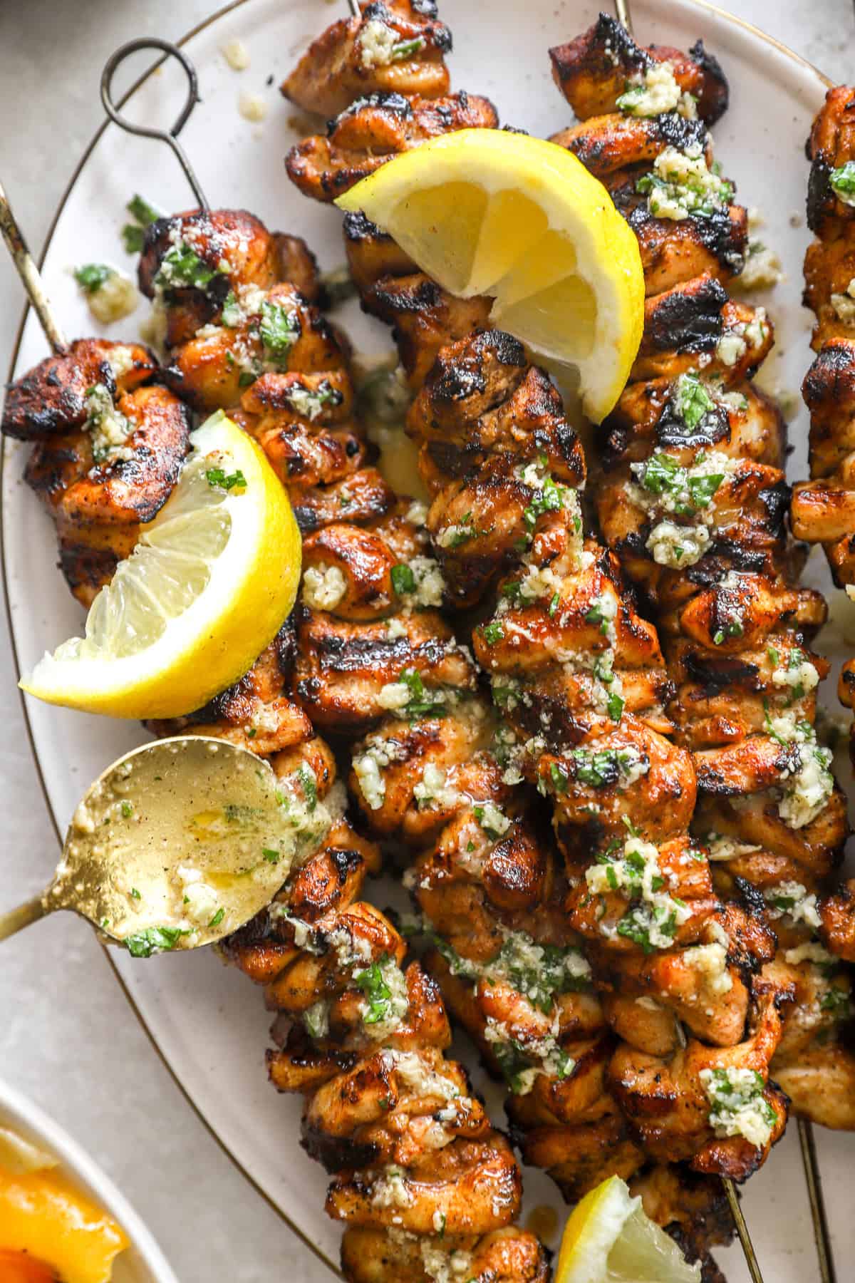 A platter of lemon pepper Parmesan garlic chicken skewers.