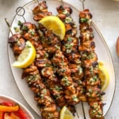 A platter of grilled lemon pepper Parmesan chicken skewers.