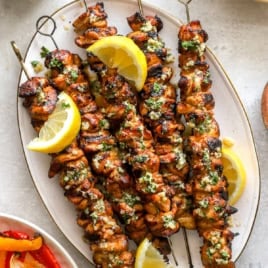 A platter of grilled lemon pepper Parmesan chicken skewers.