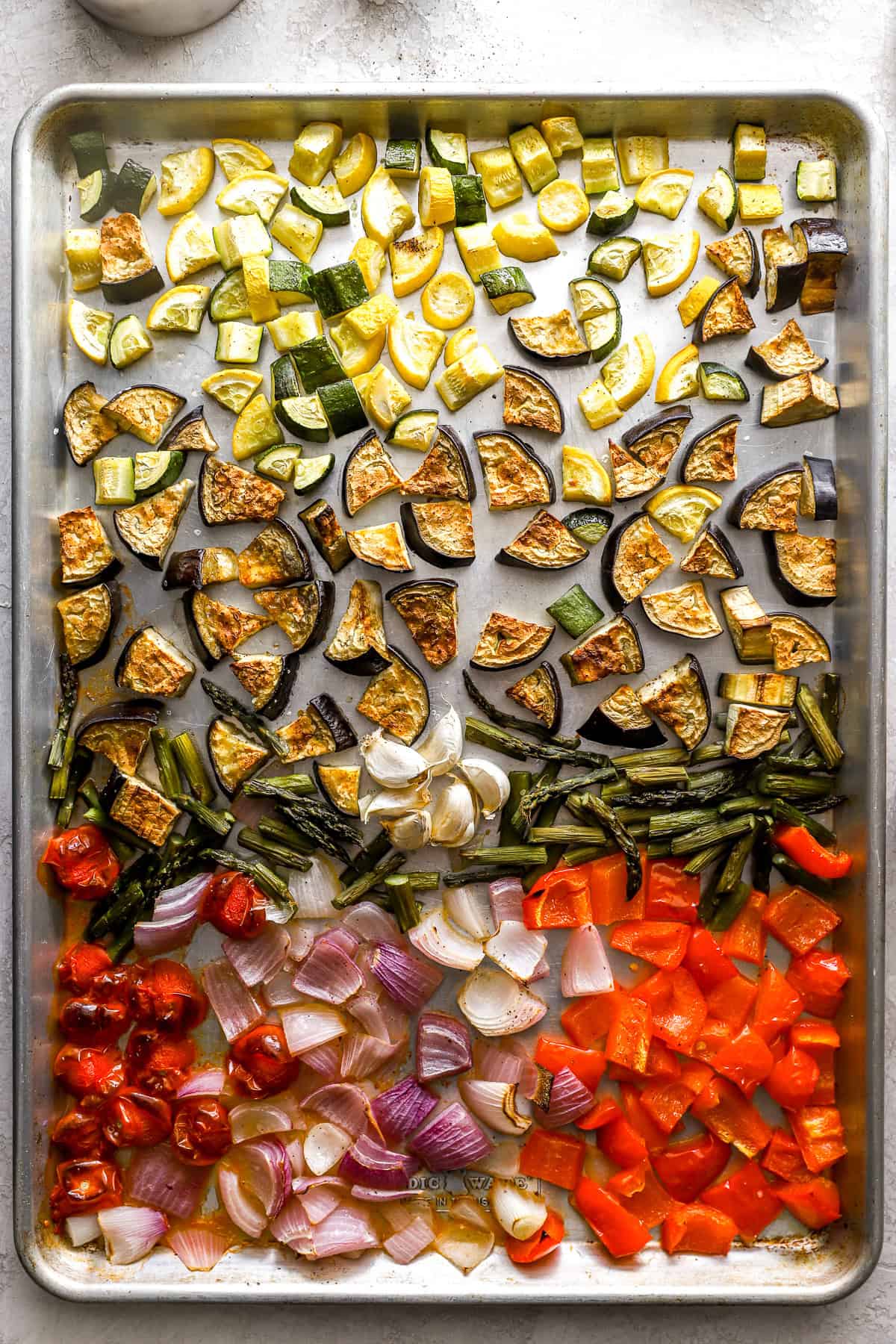 Roasted Mediterranean vegetables on a baking sheet.